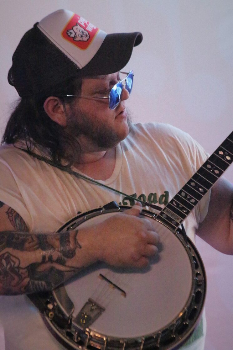 Close up of Levi playing banjo at Flood City Music Festival